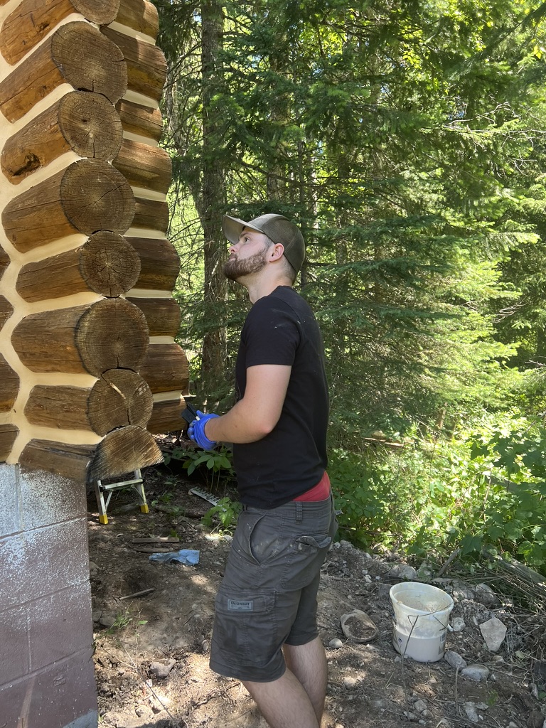 Pacific Home Renewals crew member inspecting log home chinking