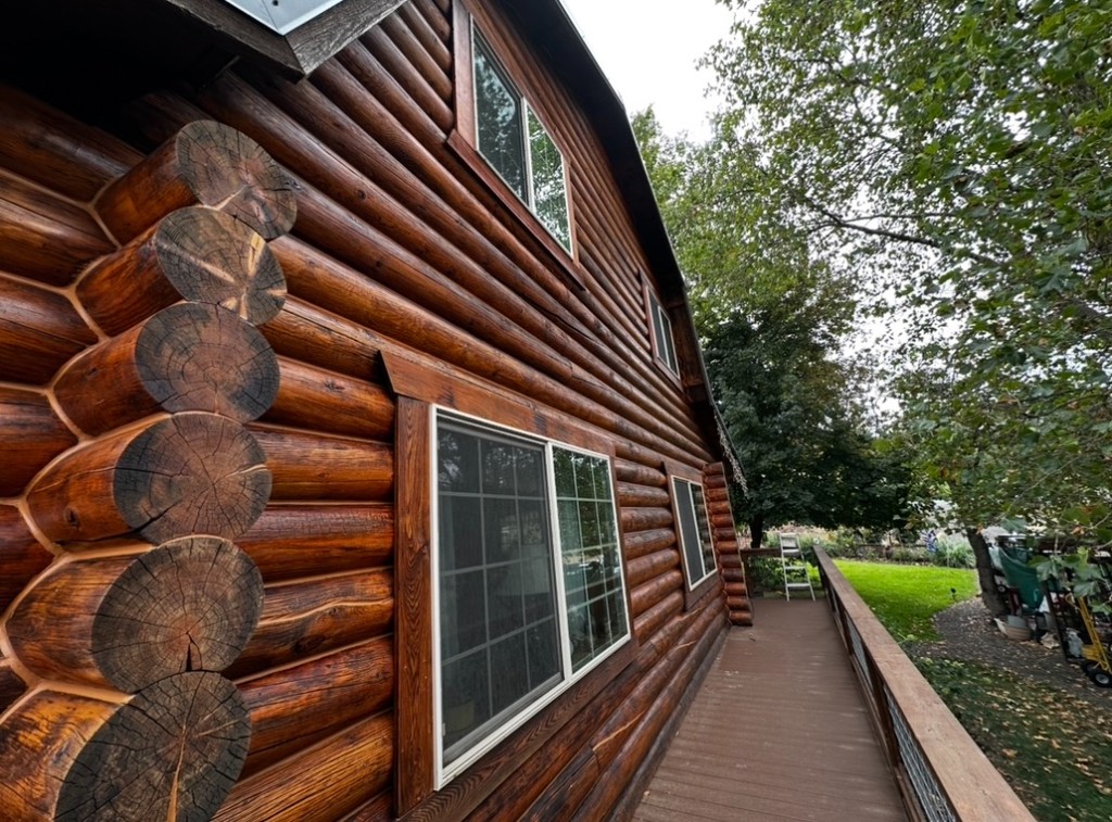 Richly stained log home exterior along a covered walkway